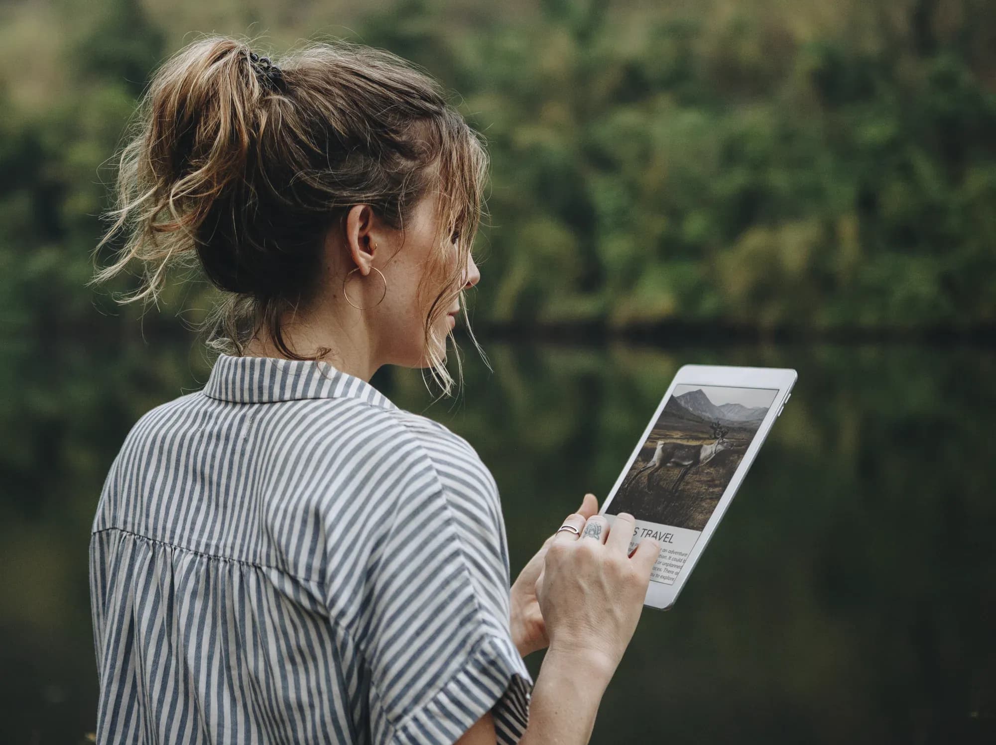 woman on tablet in forest