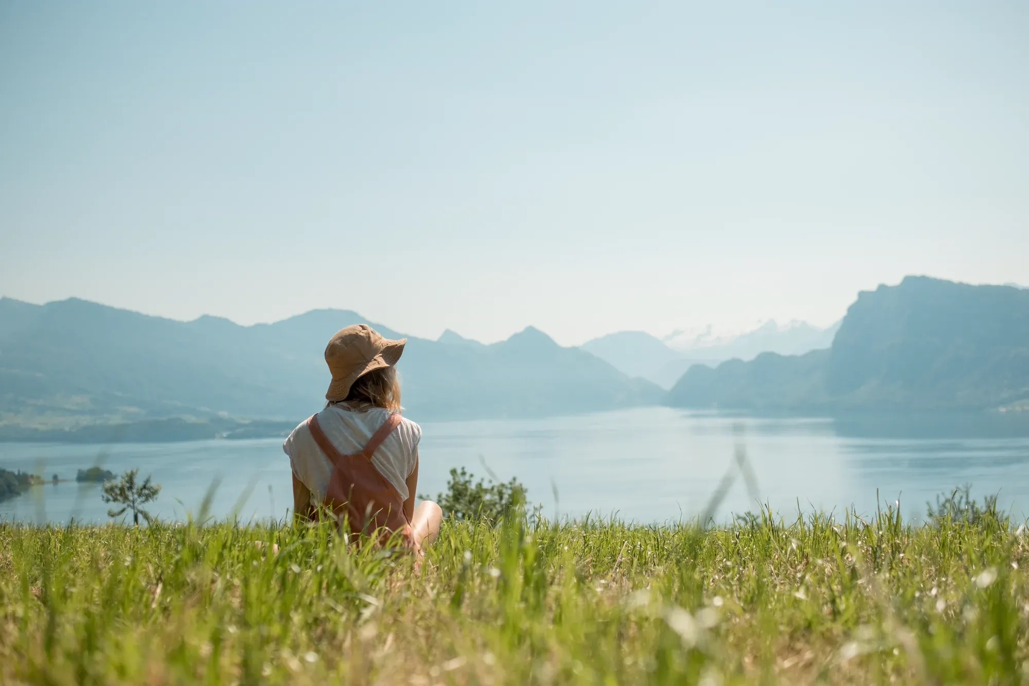 girl-with-had-sitting-green-lawn-near-lake